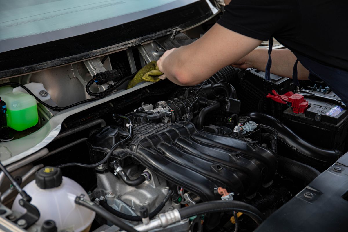 Close view of a mechanic working on a vehicle engine