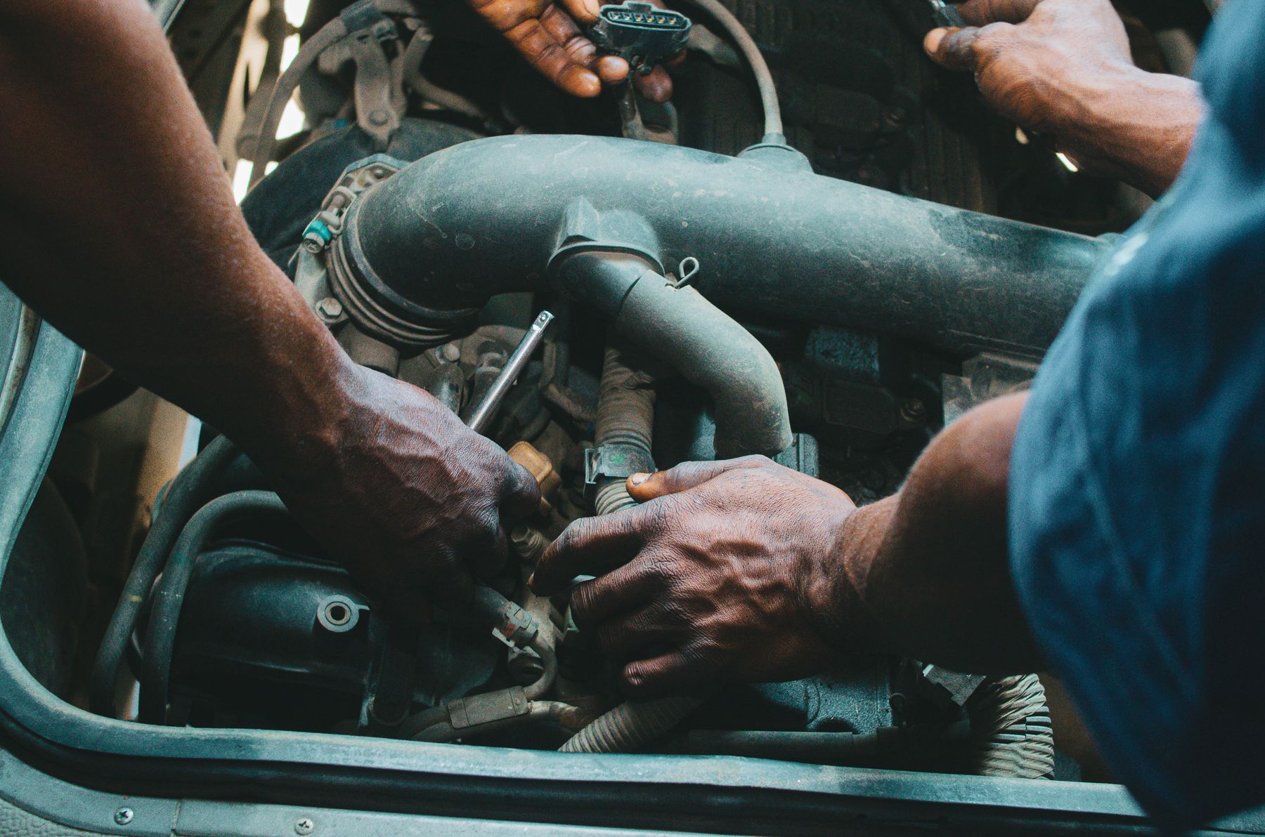 Mechanics examining a vehicle engine