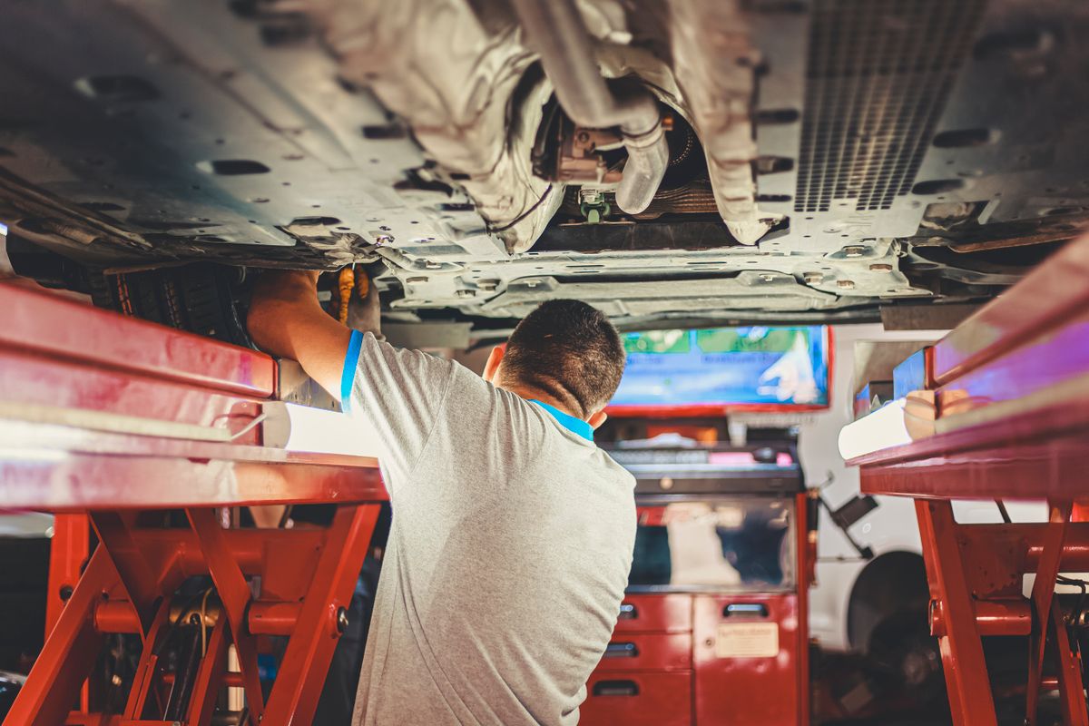 Mechanic working beneath a lifted vehicle