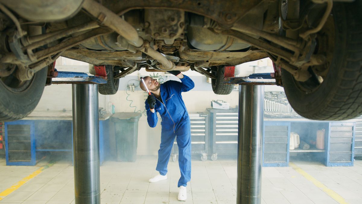 Mechanic inspecting a vehicle on a lift